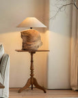 Custom-crafted wooden lamp on elegant wooden table in cozy living room setting with soft lighting.