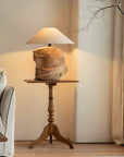 Custom-crafted wooden lamp on elegant wooden table in cozy living room setting with soft lighting.