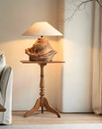 Custom-crafted wooden lamp on a wooden side table in cozy living room setting.