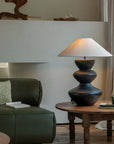 Stylish Hill Table Lamp with a linen shade and ceramic body on a wooden table in a cozy living room setting.