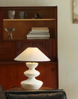 Hill Table Lamp with linen shade and ceramic base on table in cozy room ambiance.