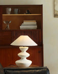 Hill Table Lamp with linen shade and ceramic base on table in cozy room ambiance.