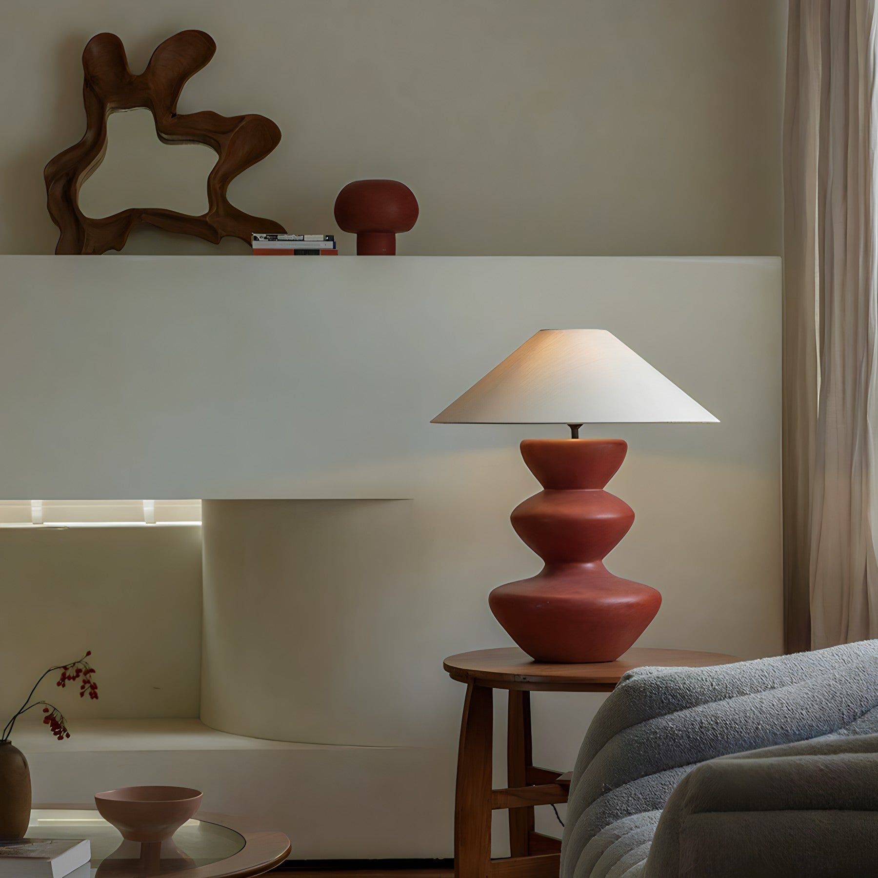 Cozy living room with elegant ceramic pot table lamp featuring a linen shade on a wooden side table, enhancing warm ambiance.