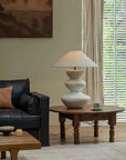 Elegant Hill Table Lamp with linen shade and ceramic body on a wooden table, enhancing the cozy living room decor.