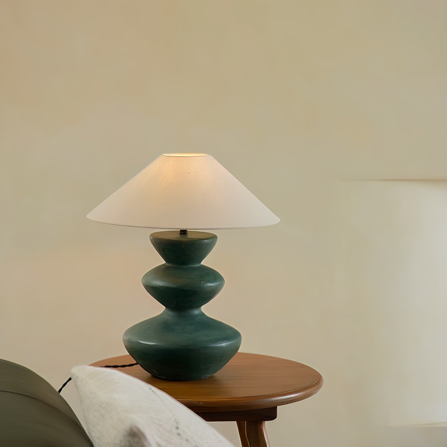 Elegant Hill Table Lamp with a linen shade and ceramic base, adding artisanal grace to a room, placed on a wooden table.