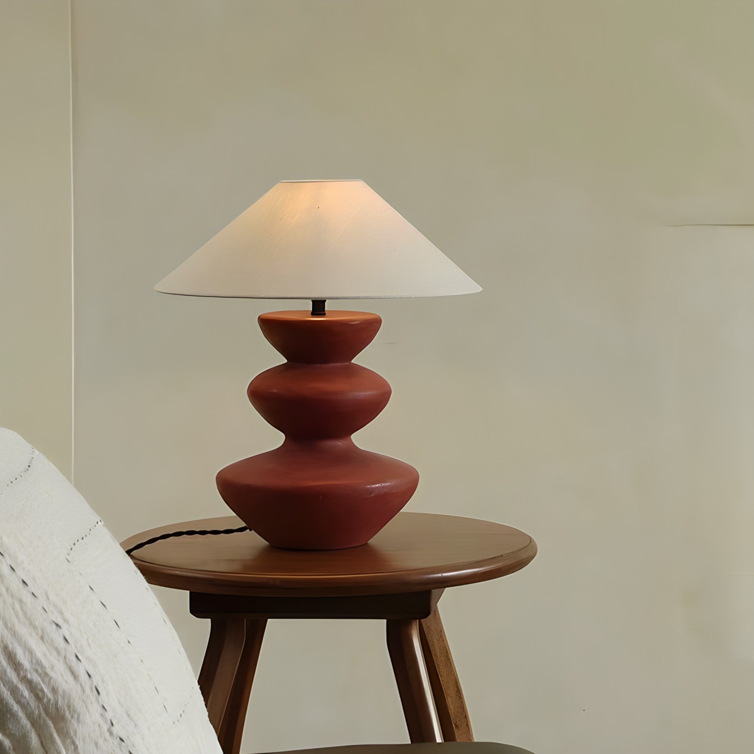 Hill Table Lamp with linen shade and ceramic base, displayed on a wooden side table in a cozy room setting.