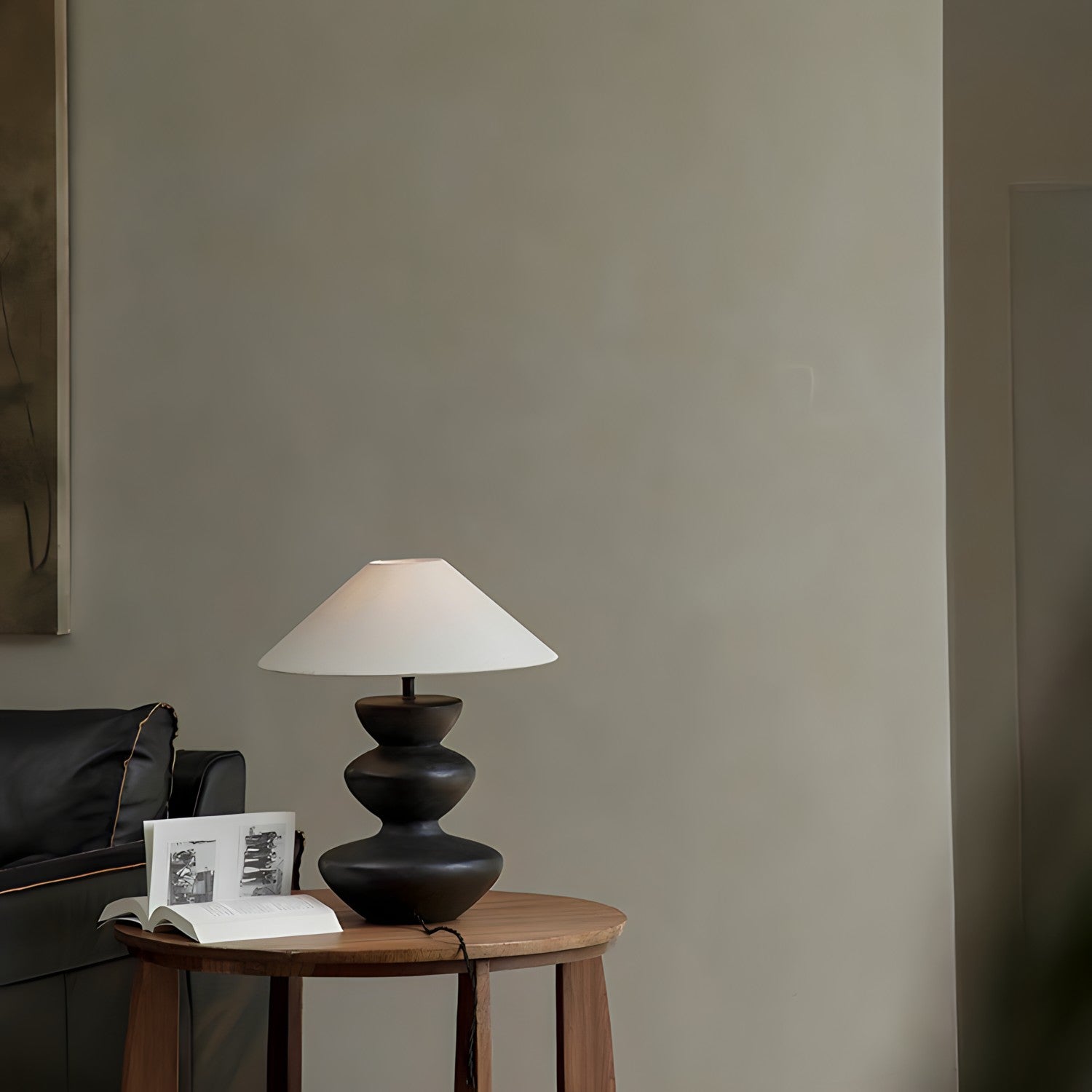 Elegant Hill Table Lamp with linen lampshade and ceramic base on a wooden side table, adding rustic charm to a modern living room.