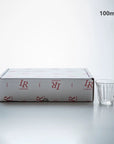 Zinc coffee glass cup with ridged design next to branded packaging, 100ml capacity, made in France.