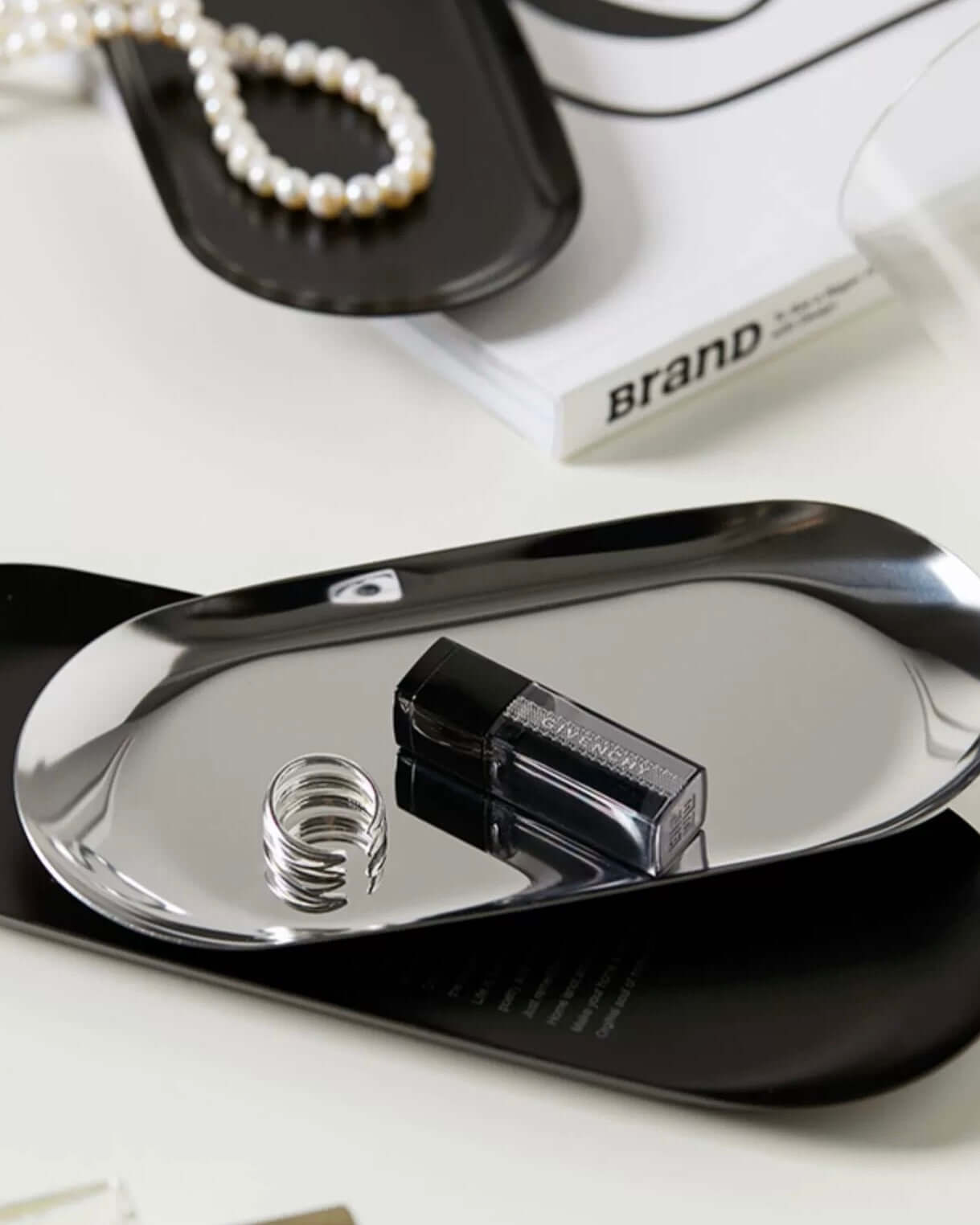 Minimalist stainless steel tray with sleek design, ideal for display and serving, styled with jewelry and cosmetics.