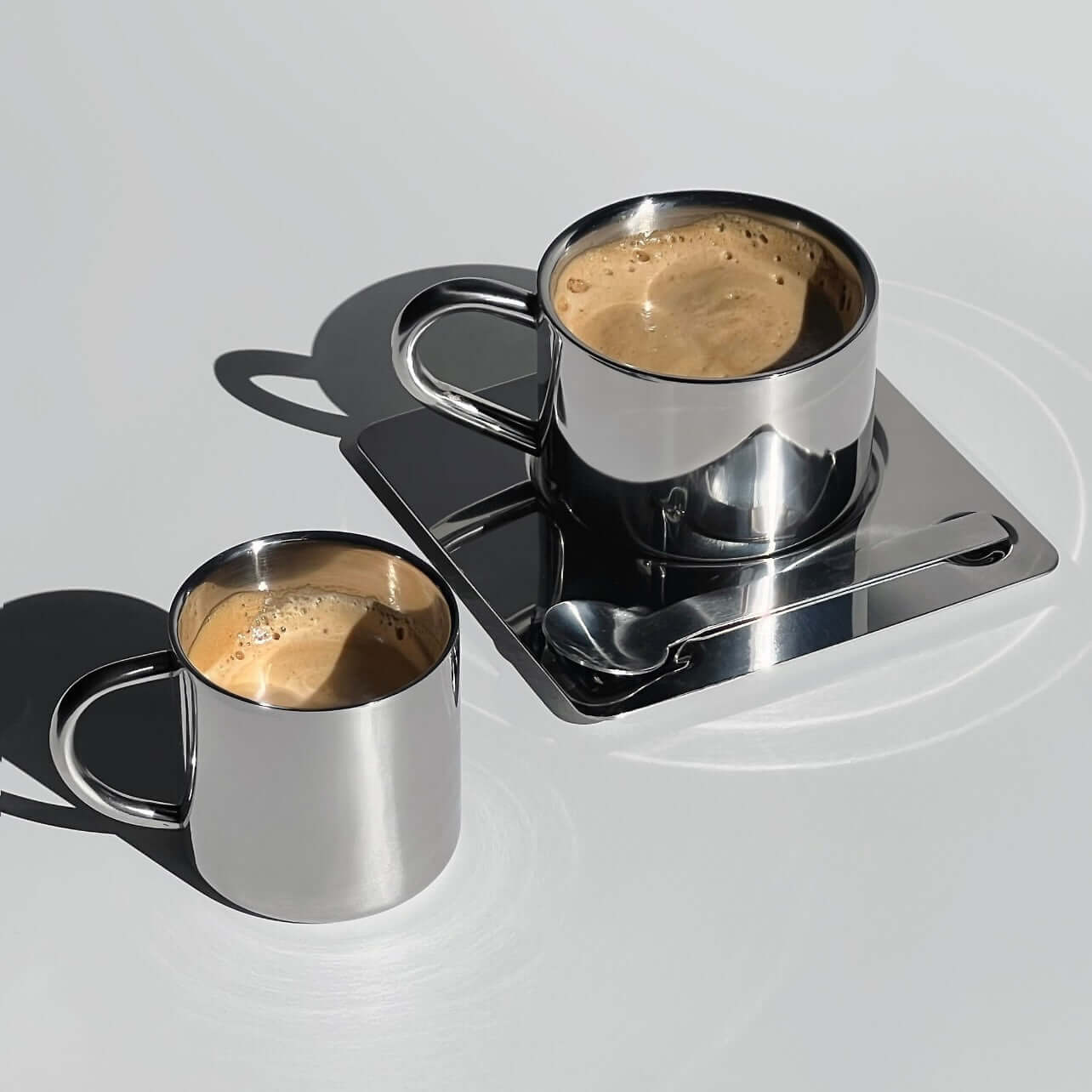Venice Mirror Cup set with polished finish, featuring two elegant cups on a saucer with a spoon, perfect for a luxurious coffee experience.