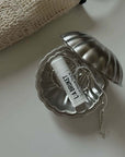 Vintage Metal Shell Box open on a bed, holding a folded card