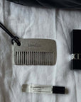 LoveÉcru Vintage Metal Comb with a lipstick and perfume sample on white linen