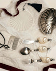 Ocean Bundle pieces laid on a white cloth with a dark red ribbon