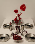 Stainless Steel Champagne Flutes on a table with red flowers and steel plates