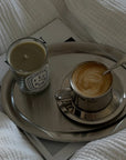Matte Stainless Steel Oval Plate with a latte and a candle on a bed