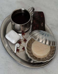 Vintage Metal Shell Box on a steel tray with a coffee cup, comb and soap