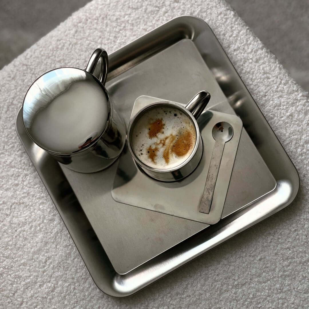 Luxurious stainless steel serving tray with elegant cups, showcasing an urban chic and minimalist design.