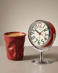Morning Ritual Set: red Crushed Ceramic Mug with coffee beside the red Orbit Alarm Clock