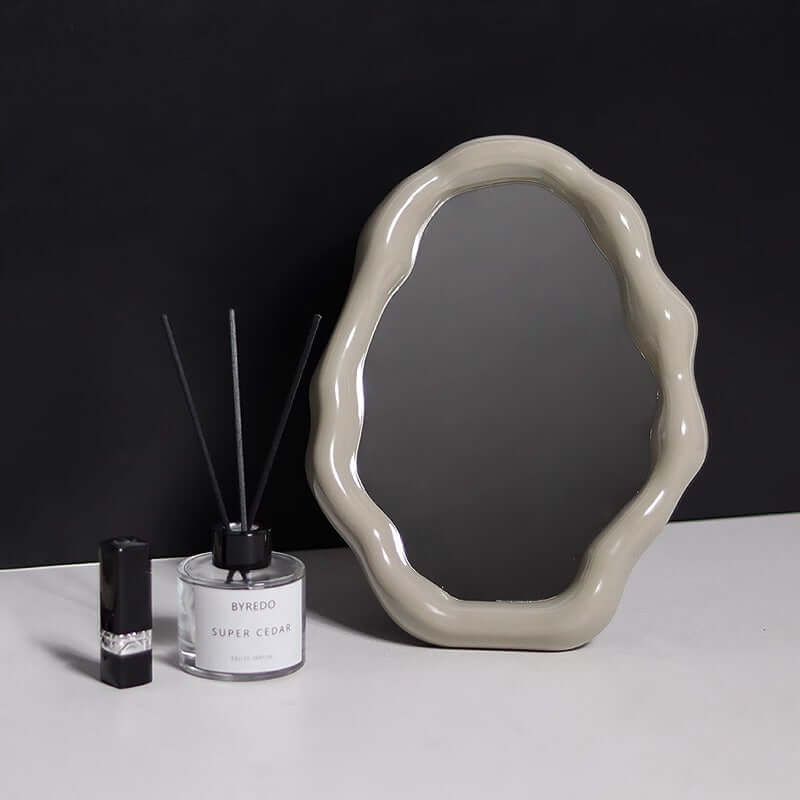 Nordic cloud-shaped vanity mirror with unique frame, measuring 27x20cm, displayed next to home decor items on a dark background.