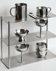 Aesthetic stainless steel shelf with polished cups and bowls, perfect for elegant and functional home decor.