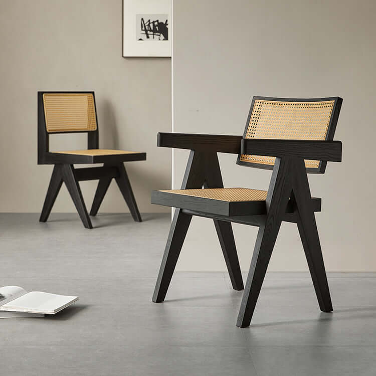 Black wood dining chairs with natural woven seats in a minimalist room setting.