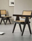 Black wood dining chairs with natural woven seats in a minimalist room setting.