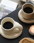 Artisan Nordic chubby mugs on plates with coffee and candle, showcasing minimalist clay design and free shipping promotion.