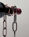 Unique chain wine bottle holder displaying a bottle, creating an illusion of suspension. Perfect for wine lovers and home decor.