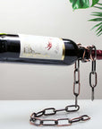 Chain wine bottle holder creatively suspends a wine bottle, adding a unique touch to home decor.