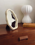 Nordic cloud-shaped vanity mirror on wooden dresser with a modern lamp and book, offering free shipping. Size: 27x20cm.