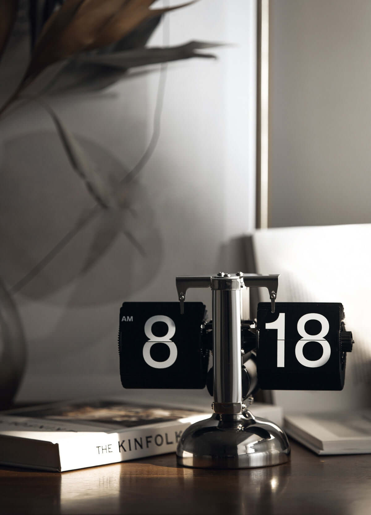 Stylish turning desktop clock with a page-turning mechanism, ideal for Japanese or Nordic-inspired interiors, on a wooden desk.