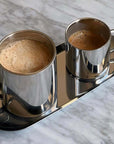 Milano Duo Set with stainless steel double-walled cups on tray, perfect for espresso or latte, on a marble surface.