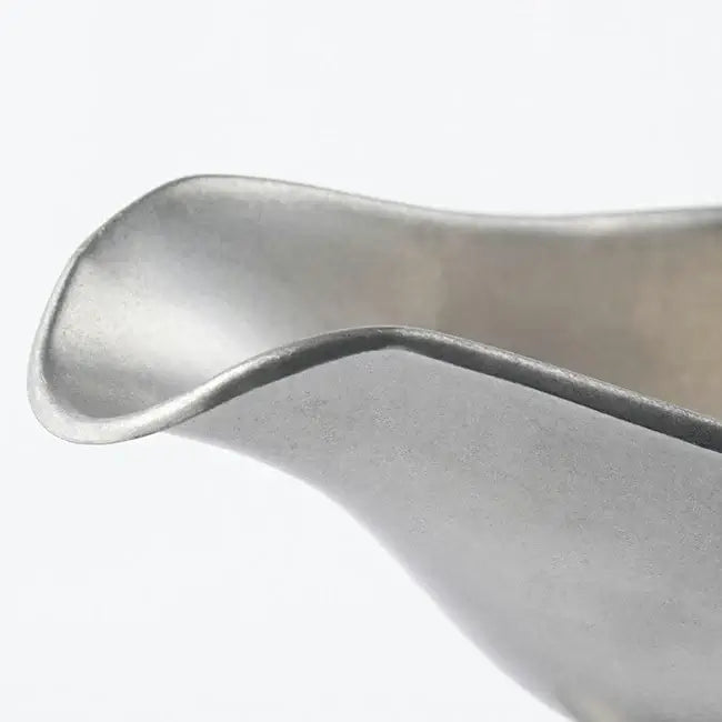 Close-up of a vintage stainless steel INOX sauce pot lip with a chic, durable design made in Japan.