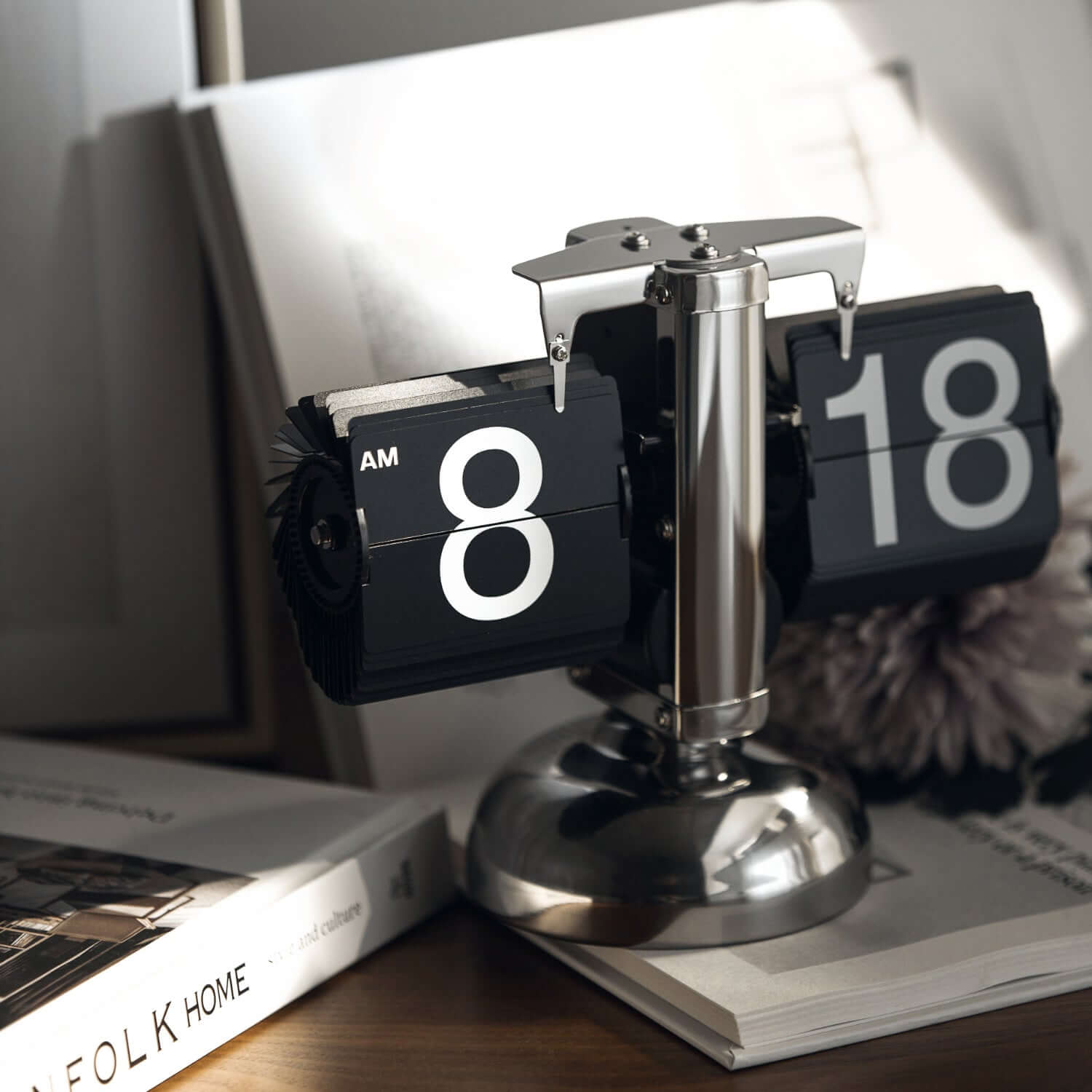 Sleek turning desktop clock with page-turning mechanism, blending Japanese and Nordic aesthetics on a minimalist desk.