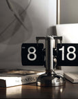 Turning desktop clock with page-turning mechanism, perfect for Japanese or Nordic interiors, on a modern desk setting.