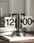 Turning desktop clock with a page-turning mechanism on a book, ideal for Japanese or Nordic inspired interiors.
