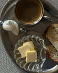 Clara Glass Shell Dish with butter on a steel tray with bread and coffee