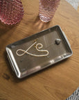Industrial Stainless Steel Tray holding a pearl necklace on a wooden table