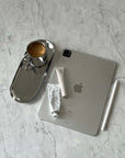 Minimalist steel tray with coffee cup next to tablet and stationery on marble surface.