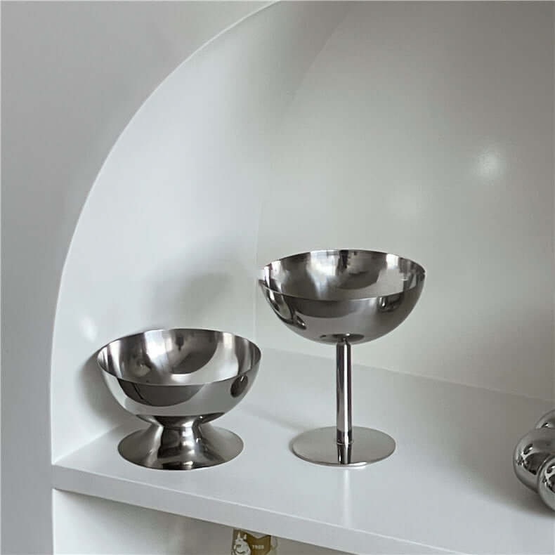 Minimalist stainless steel ice cream cups elegantly displayed on a white shelf, showcasing modern design and sophistication.