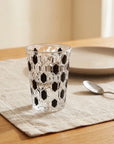 Black Vetra Raindrop glass with water on a linen tablecloth