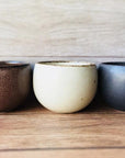 Rila Tea Cups by Kaneko Kohyo; set of three textured, matte cups in brown, white, and grey, perfect for tea, desserts, and single-serve dishes.