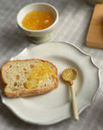 Marumitsu Bean Spoon with rustic glaze on a plate with bread and jam.
