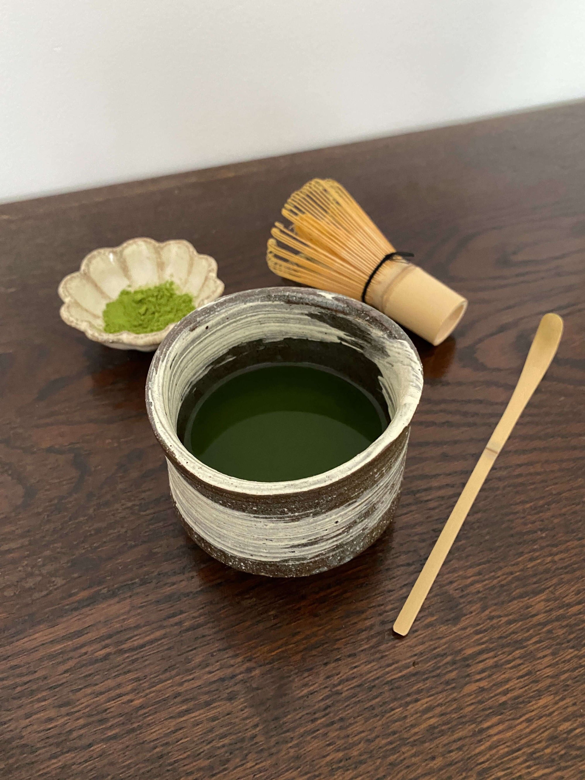 Handmade Wabi-Sabi Matcha Bowl with bamboo whisk and spoon, ceramic design for Japanese tea experience