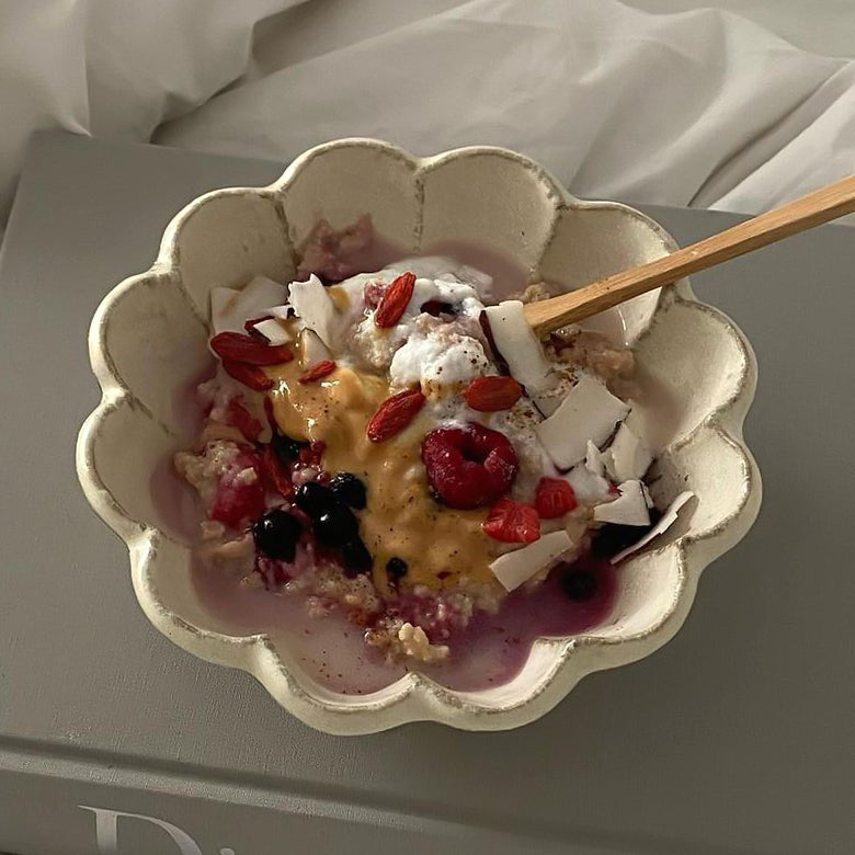 Rinka Bowl 16cm with yogurt and berries, handcrafted by Kaneko Kohyo, showcasing its flower shape and elegance on a table setting.