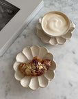 Rinka soup cup with foam and flower-shaped plate with pastry on marble table, showcasing Kaneko Kohyo's handcrafted porcelain design.