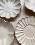 Elegant Yoshida Pottery Collection with Rinka and Yukiwa plates showcasing unique flower-like patterns and refined craftsmanship.