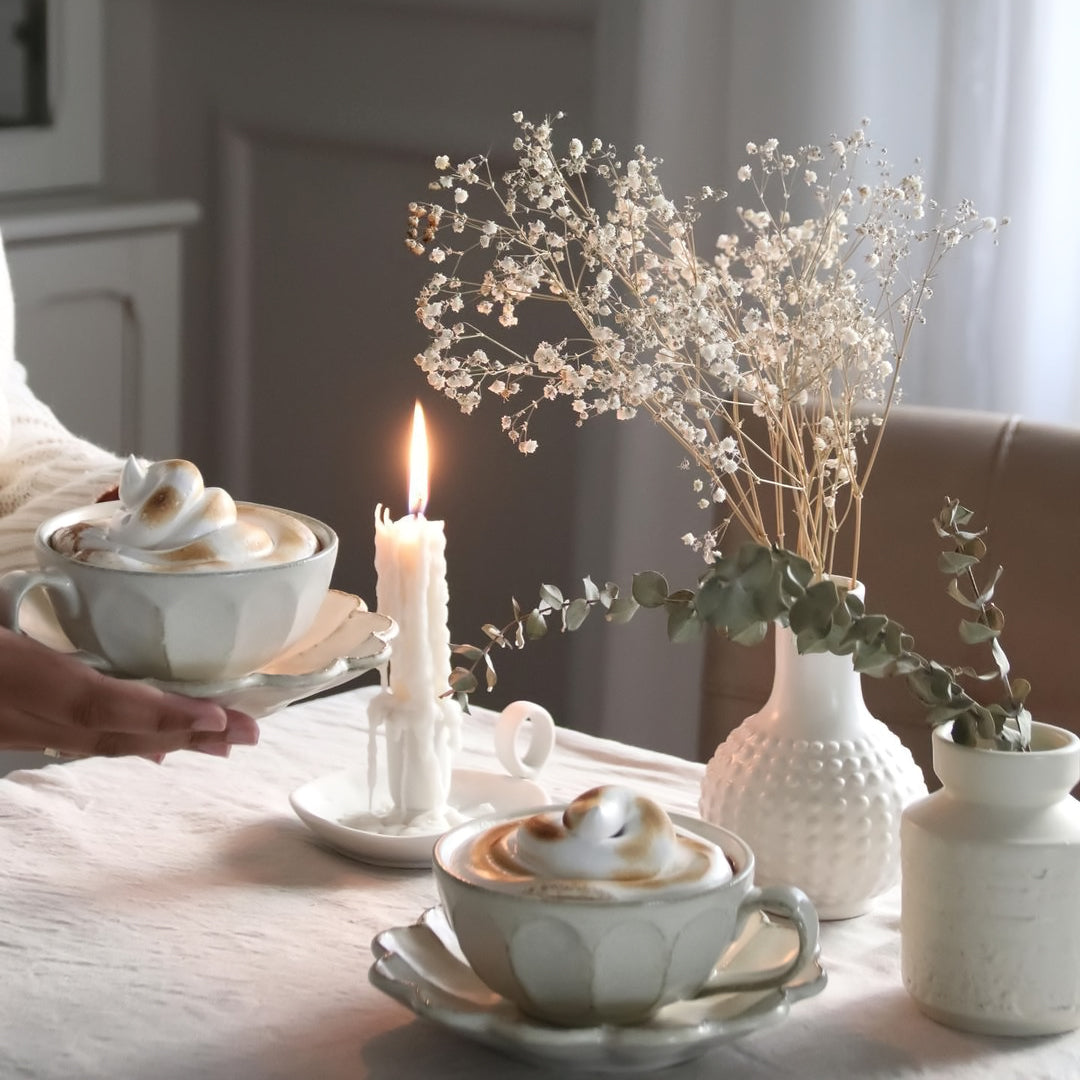 Elegant Rinka Soup Cup on table with candle and flowers, showcasing Kaneko Kohyo's handcrafted porcelain design.