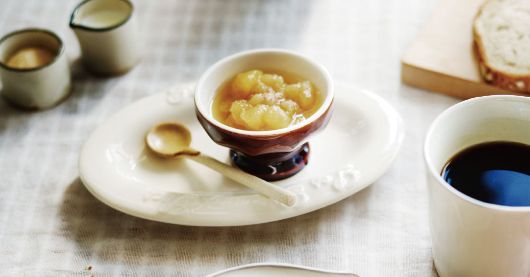 Marumitsu Bean Spoon beside dessert bowl on a table setting with coffee and bread.
