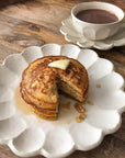 Pancakes with butter and syrup on a Rinka porcelain plate, paired with coffee in a matching Rinka mug, showcasing elegant Japanese craftsmanship.